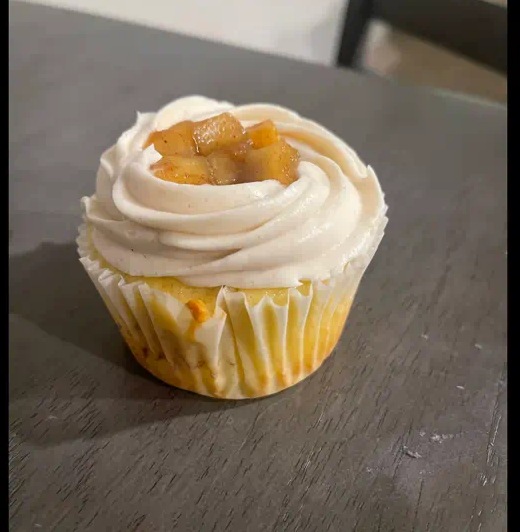 Cupcake with swirled frosting and a glazed fruit topping